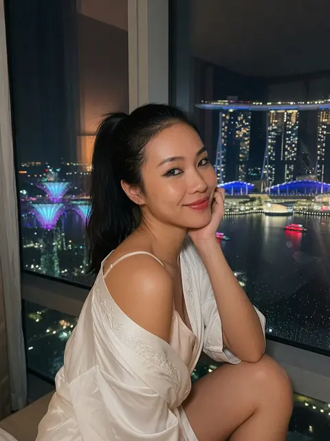 Vietnamese cam model in a silk robe by a Marina Bay window